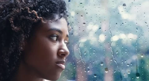 young-woman-looking-out-through-rain-covered-window-768