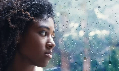 young-woman-looking-out-through-rain-covered-window-768